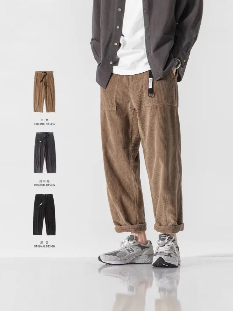 Man wearing loose straight-leg tapered trousers in dark grey, showing the full length and relaxed fit.