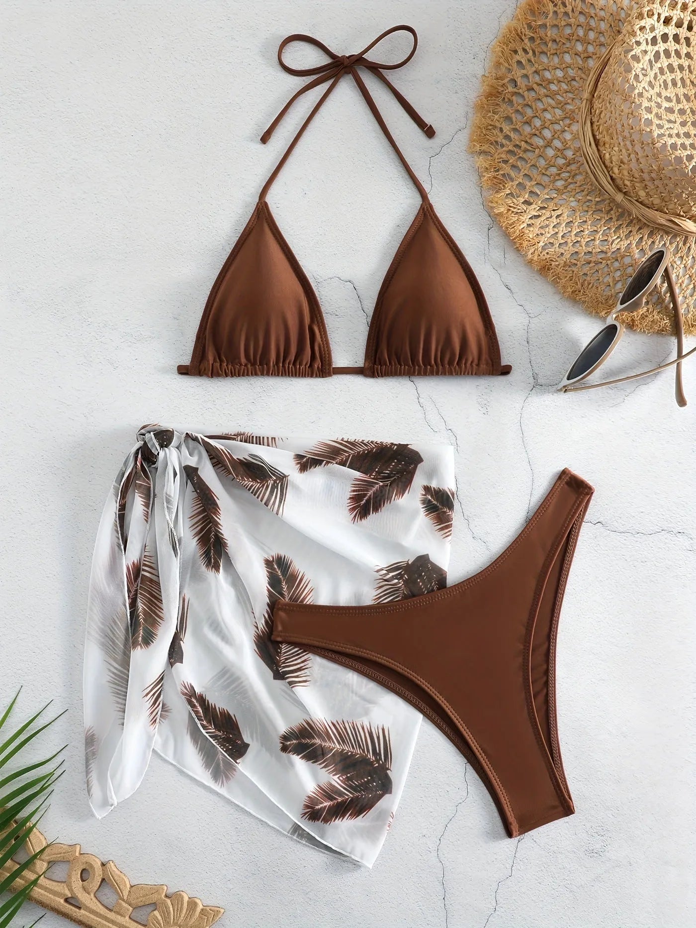 Orange three-piece bikini swimsuit set with a matching printed gauze skirt laid flat.