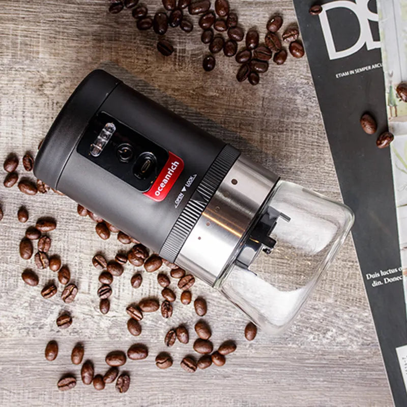 Black portable hand crank coffee grinder with manual grinding mechanism on counter