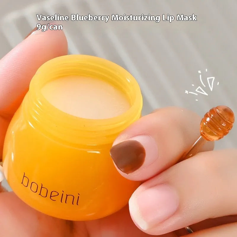 Vaseline Moisturising Lip Balm pot in blueberry or pomegranate flavour, 9g net content with applicator brush.