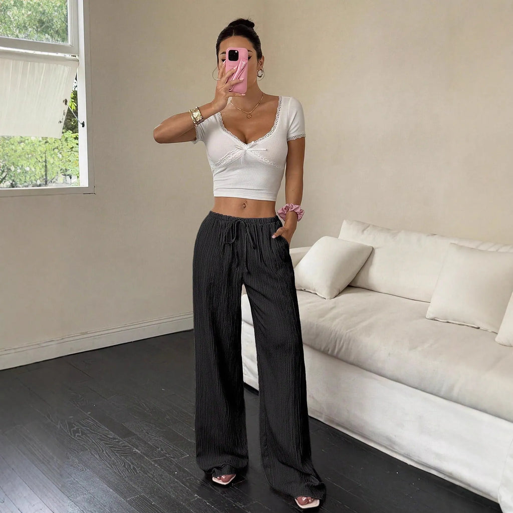 Women's wide-leg black trousers with a lace-up detail on the mid-rise waist