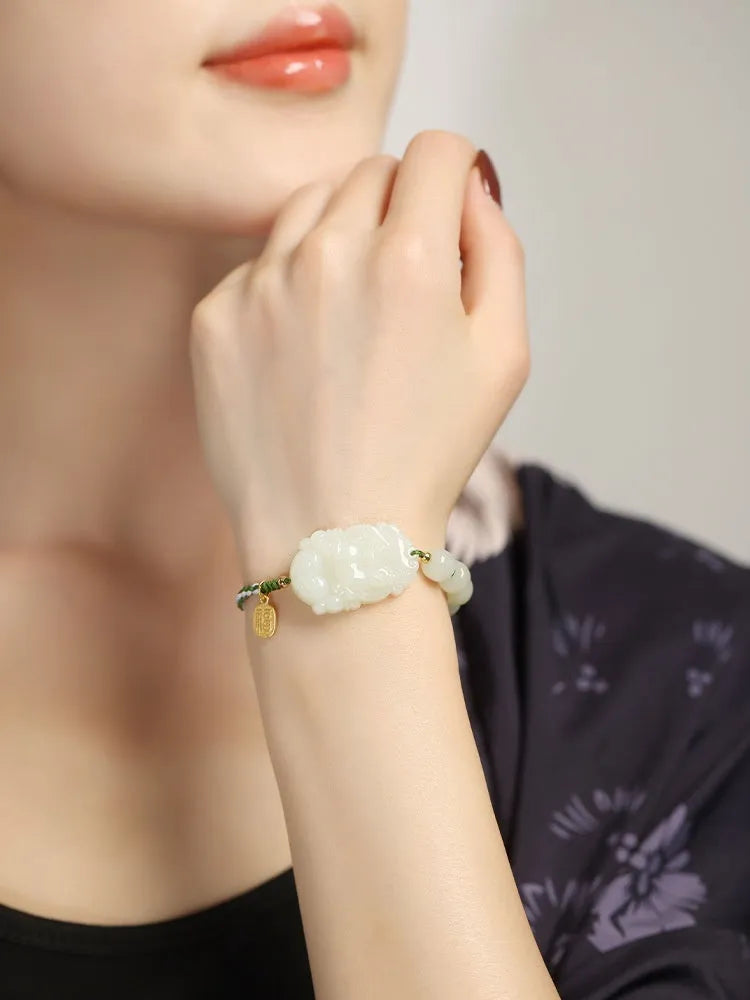 Year of Rabbit red rope bracelet with Hetian jade bead and S925 silver card on a white background.