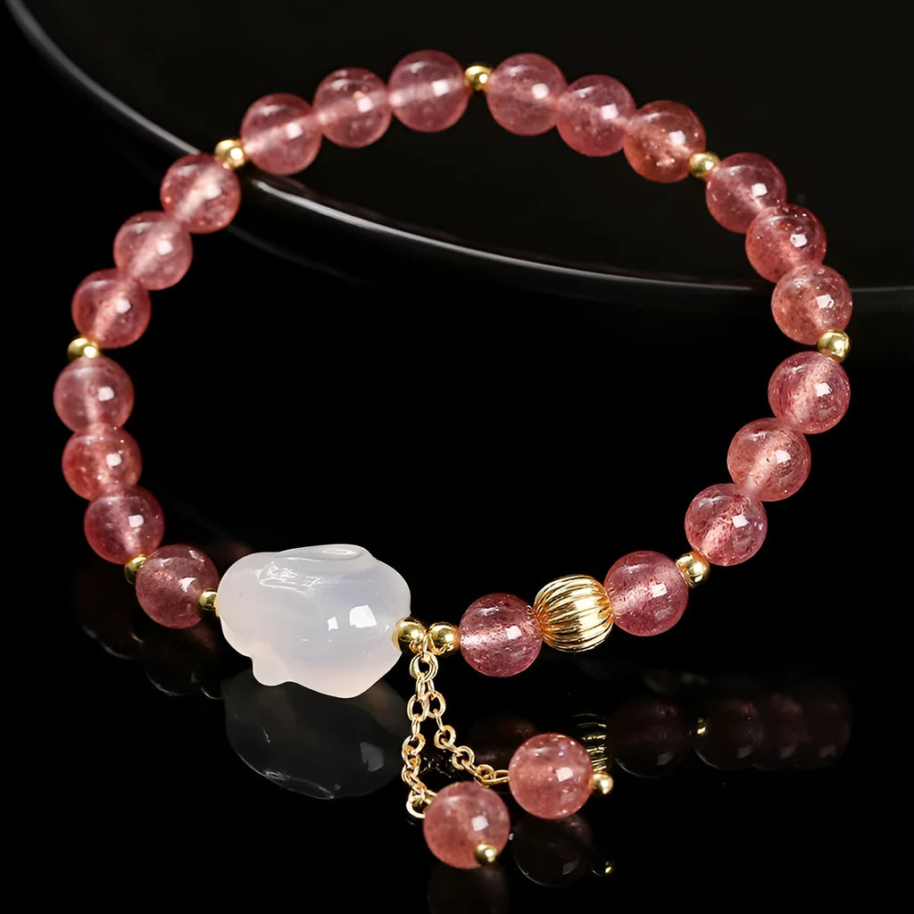 Women's strawberry quartz and agate bracelet with 6mm round beads and a white rabbit charm pendant.
