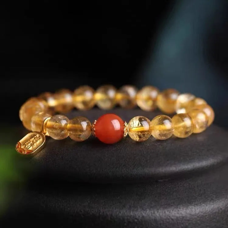 Polished natural red agate bead bracelet on a wrist, showing smooth beads.
