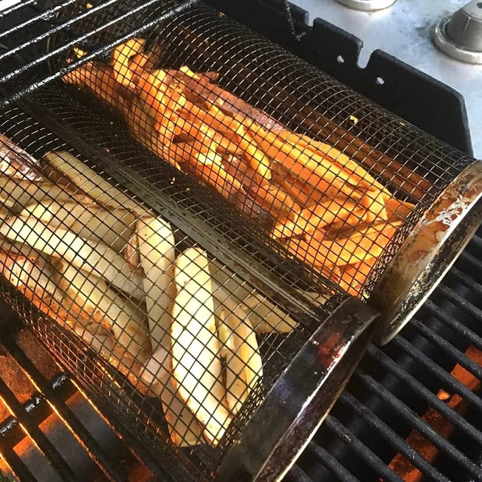 Round silver metal rolling barbecue basket with wire mesh and a hook, shown with vegetables inside on a grill.
