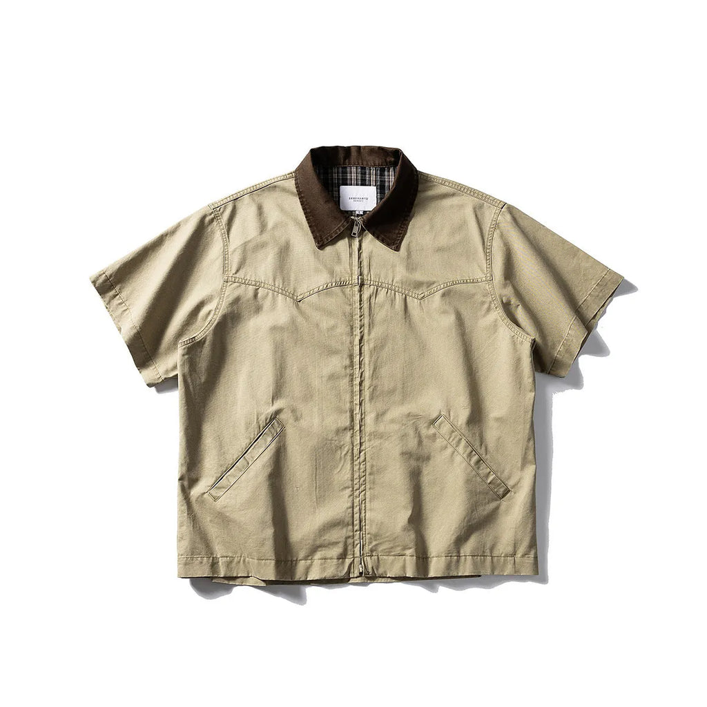 A khaki-coloured, loose-fitting, short-sleeved cotton shirt styled as washed overalls for teenagers