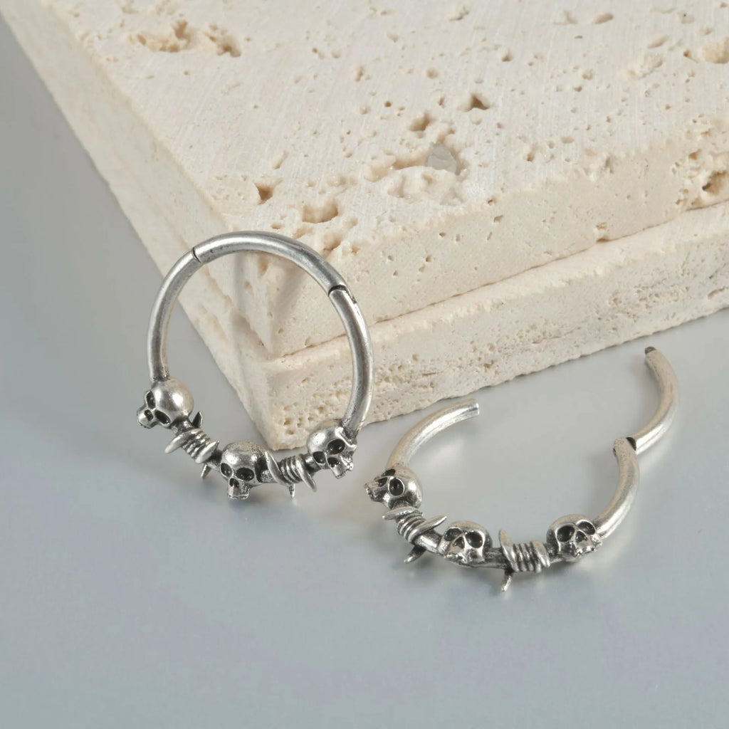 Close-up of copper punk earrings with a detailed ghost head design in antique silver finish.