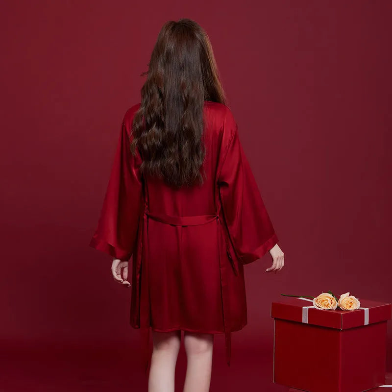 Red matching men's and women's ice silk sleepwear set with long sleeves and trousers.