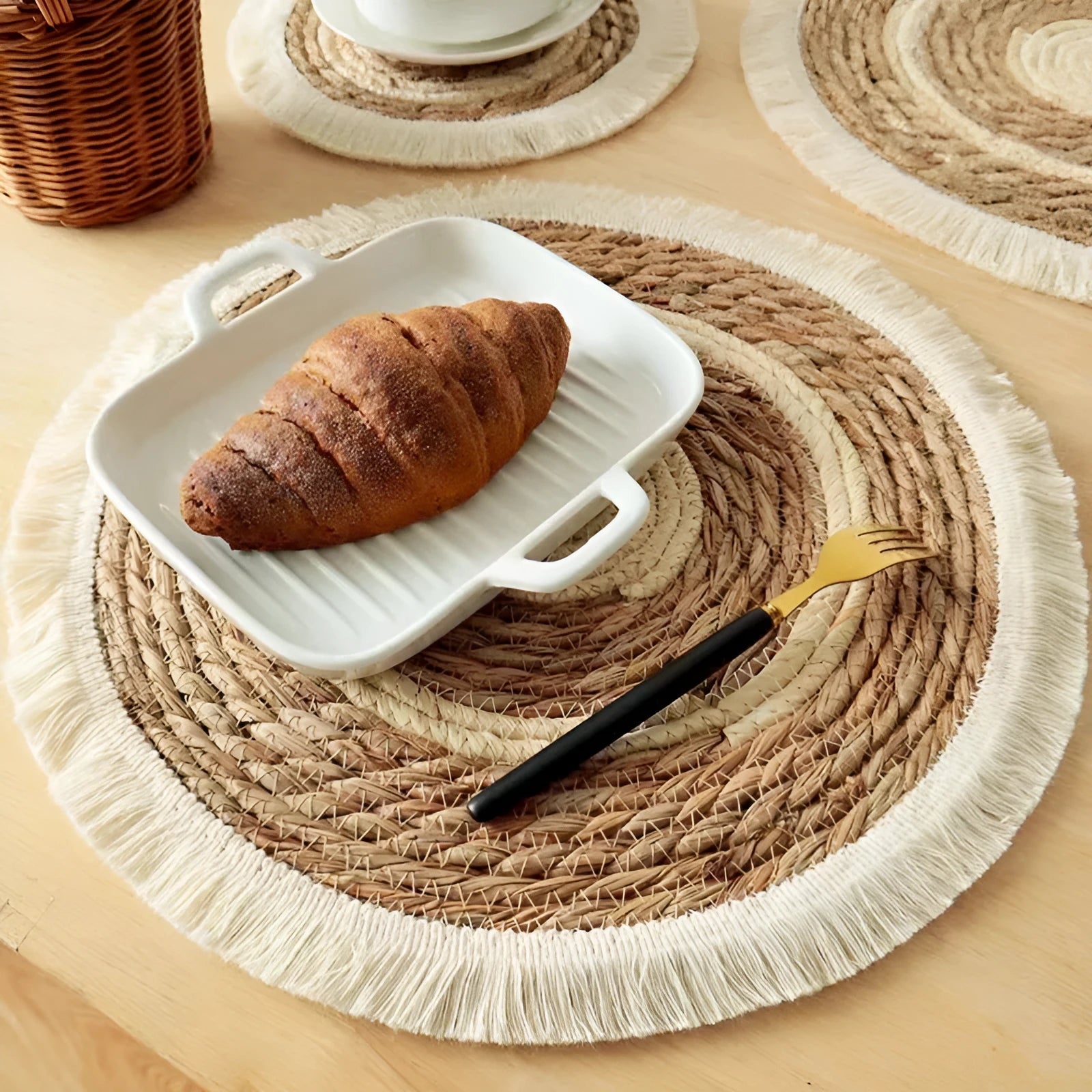 Round Japanese straw placemat with tassel edge in natural papyrus material on wooden dining table
