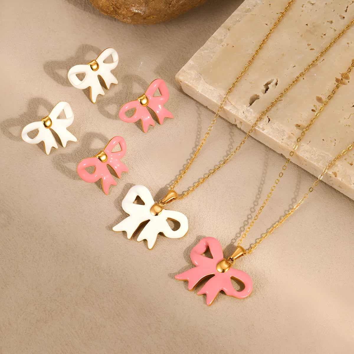 18K gold plated stainless steel bowknot necklace with adjustable chain and matching stud earrings on white background