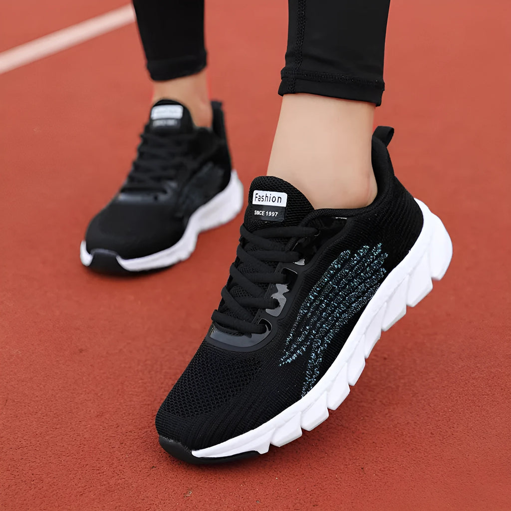 Women's low-top platform sneakers in black and white with cross-strap detail and MD sole.