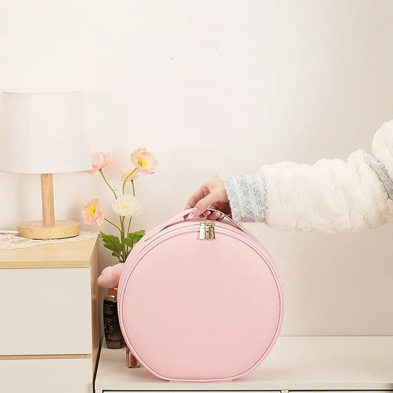 Round pink PU leather makeup bag with LED mirror open, showing internal partitions and carry strap.