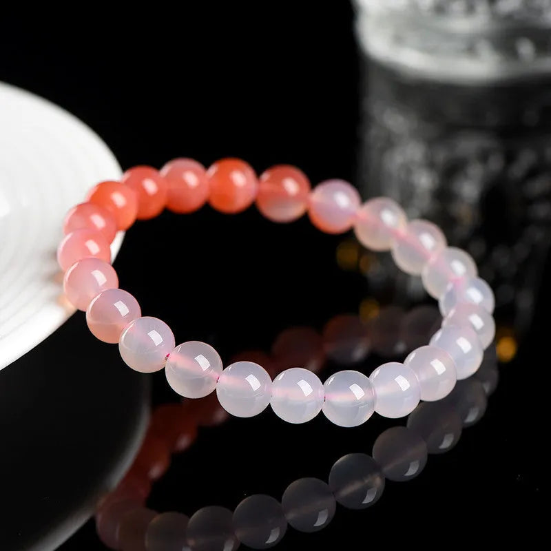 Natural gradient Yanyuan agate bracelet with geometric cut beads on a wrist.