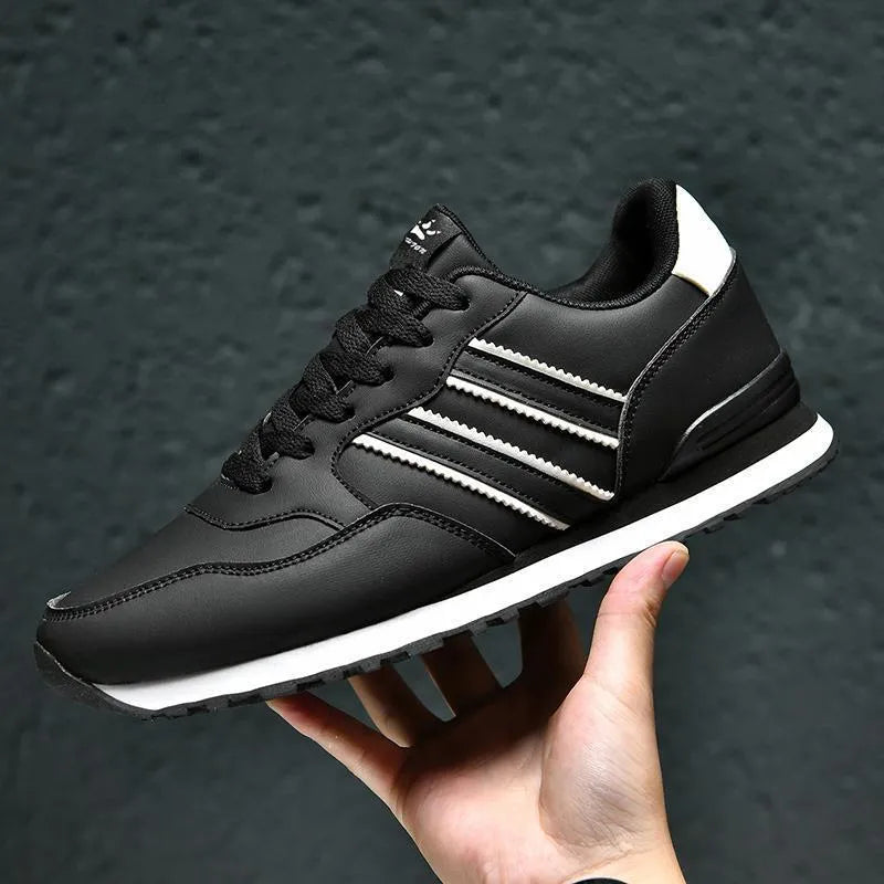 Men's black sports casual shoes with a carved wing pattern on the leather upper and a round toe.