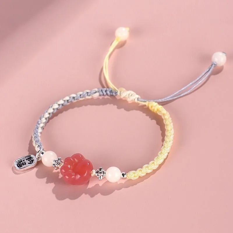 Handmade red cat's paw charm bracelet with pink woven band for couples.