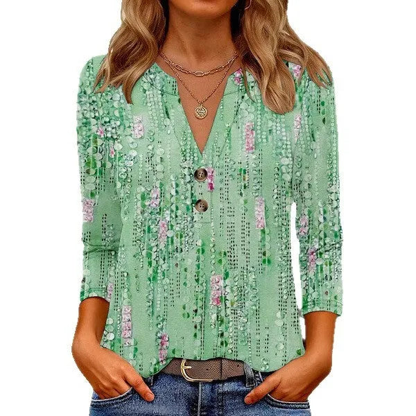Women's loose-fit V-neck top with a colourful 3D effect pattern, shown in a casual setting.