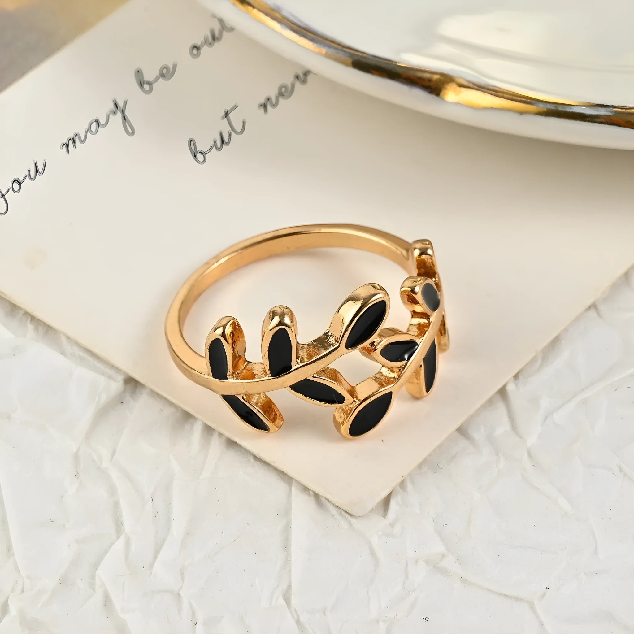 Gold geometric leaf and flower shape acrylic ring for women on index finger.
