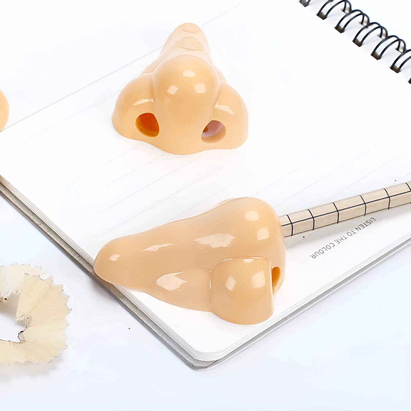 Flesh colour plastic manual pencil sharpener with big nostril and geometry shape.