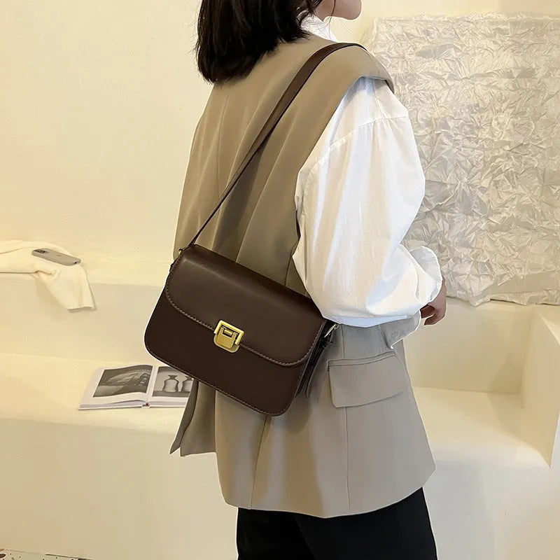 Soft black PU leather women's square cross-body bag with textured finish shown on model.