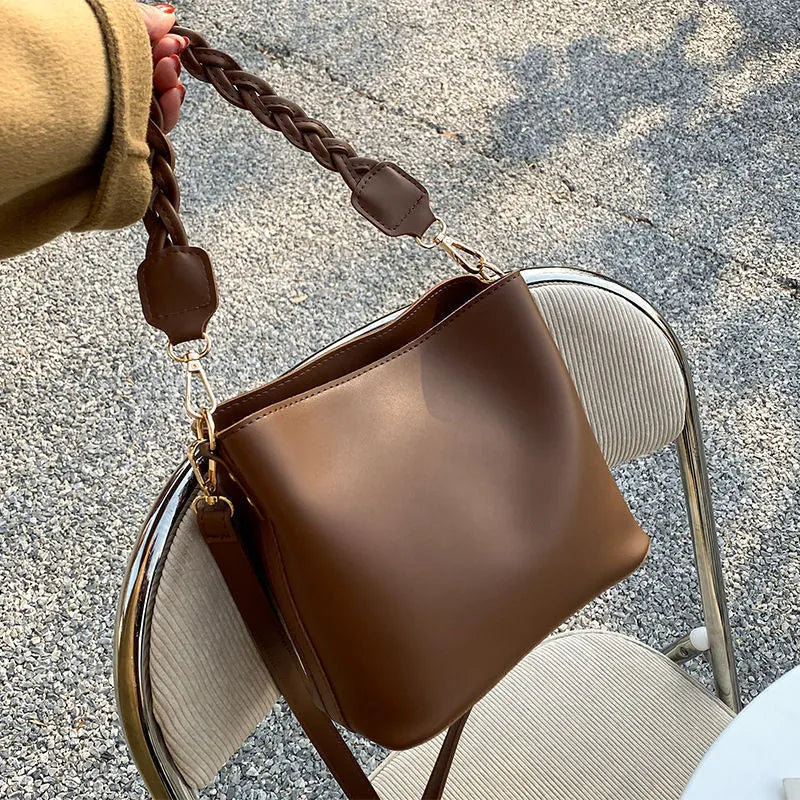 Retro khaki PU leather crossbody bucket bag with woven detail and a brown strap.