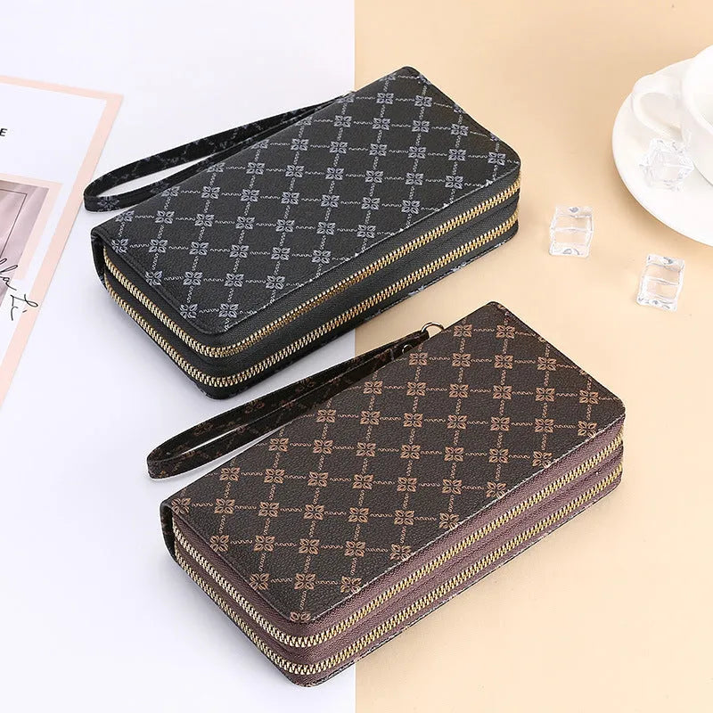 Black retro print long wallet clutch bag with zipper, holding a mobile phone and cards.
