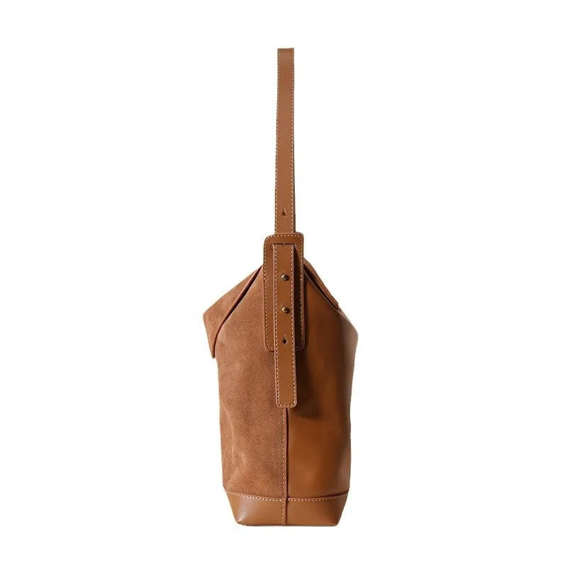 Light brown genuine leather women's retro shoulder bag with clamshell opening on a table.
