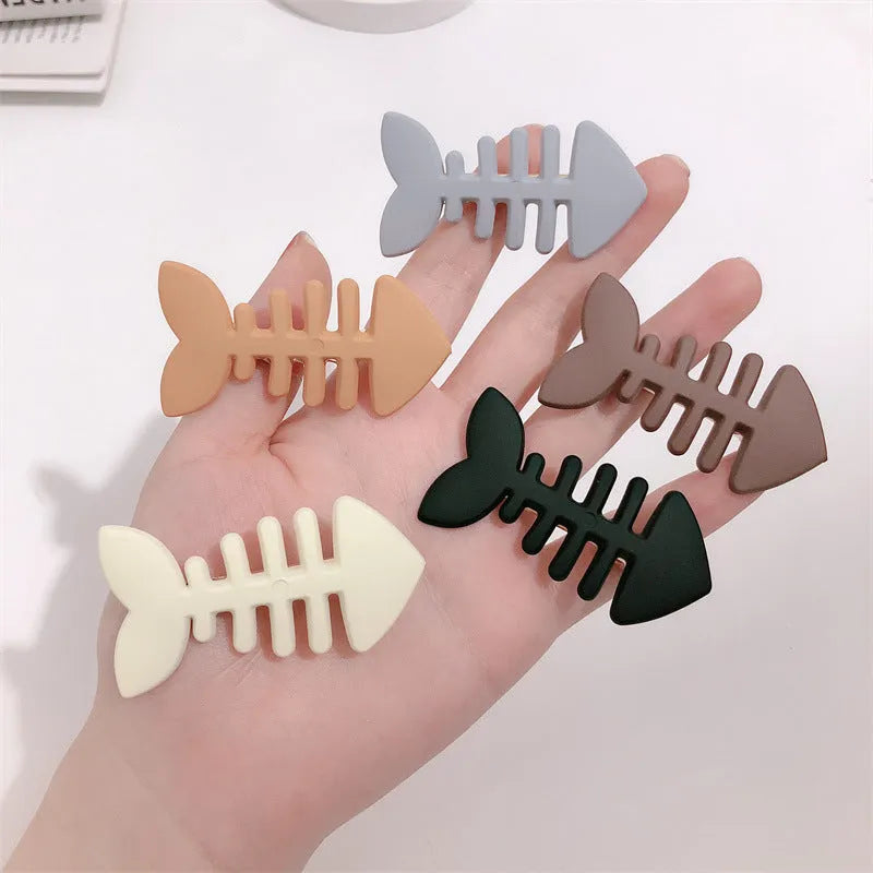 A minimalist fishbone design duckbill clip hair barrette in a muted candy colour.