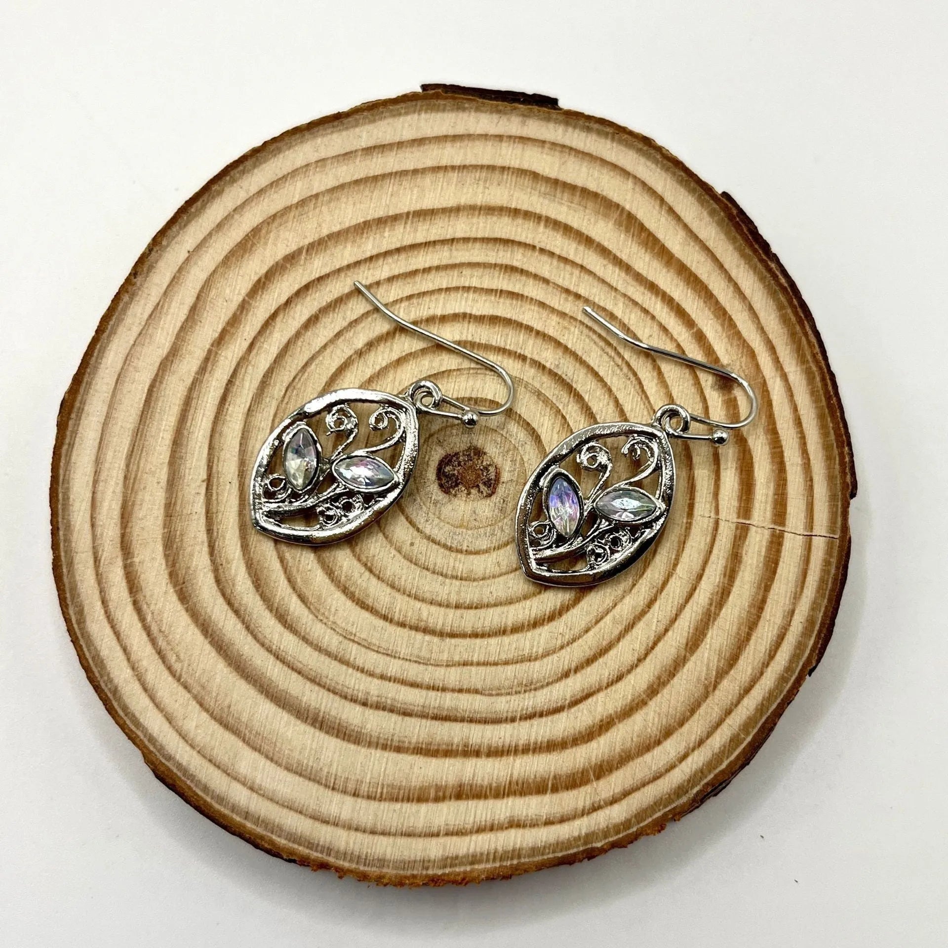 Silver alloy leaf-shaped earrings with an embedded colourful moonstone centrepiece.