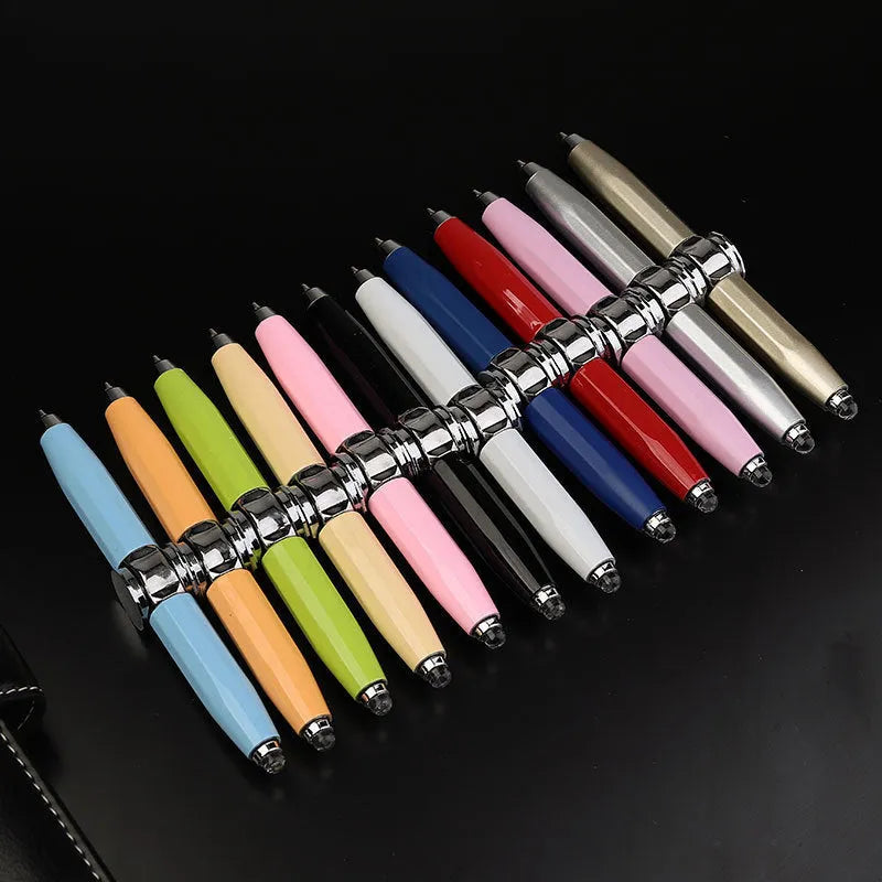Silver metal LED pen with a spinning gyro top and ballpoint tip, shown with multiple coloured ink refills.