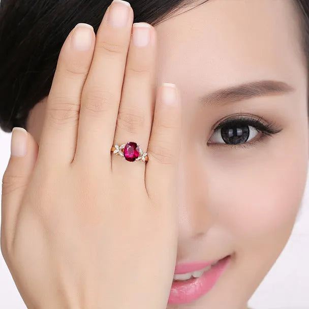 Women's copper butterfly ring with heart shape and rose gold finish showing red gemstone accent option