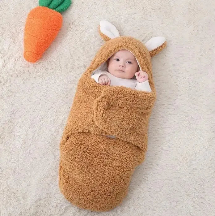 A baby wearing a soft grey fleece sleeping bag with hook-and-loop shoulder straps.