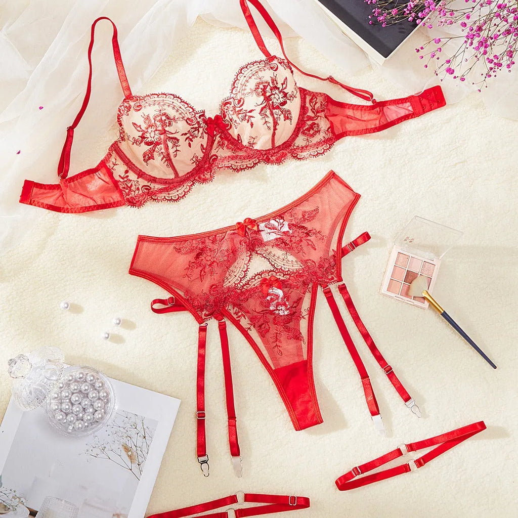 Women's embroidered underwear set with see-through mesh cutouts and matching garters in sapphire blue.