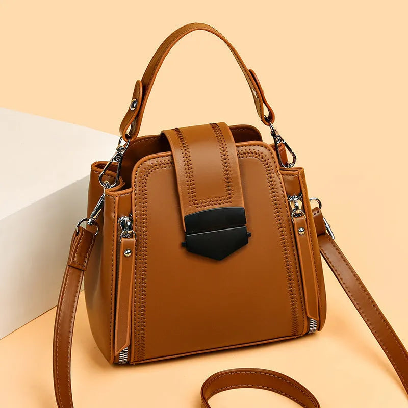 Soft textured PU leather ladies handbag in a square vertical shape with sewn thread detailing.