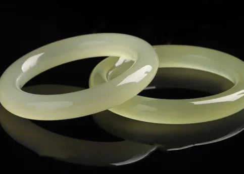 Ice-like silk jade round bar bracelet showing geometric winding design on a wrist.