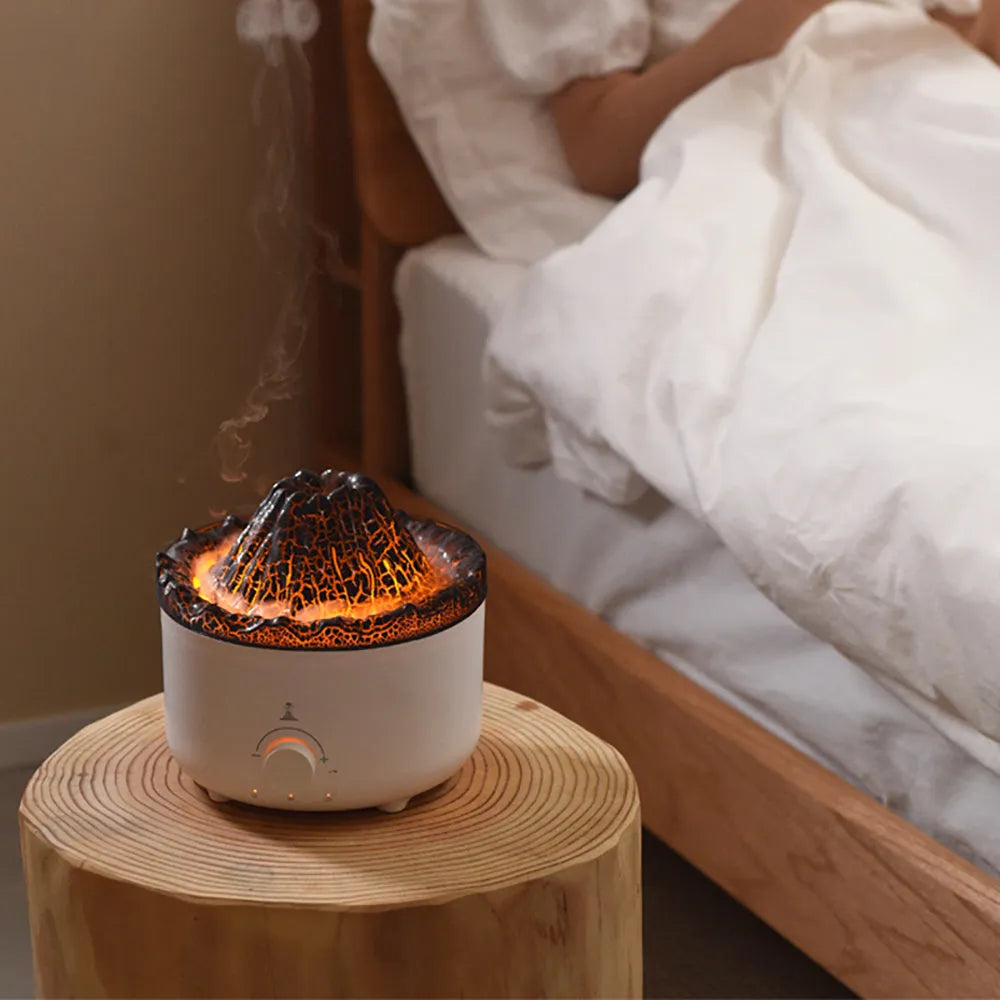 White columnar simulated flame volcano humidifier with remote control on wooden surface