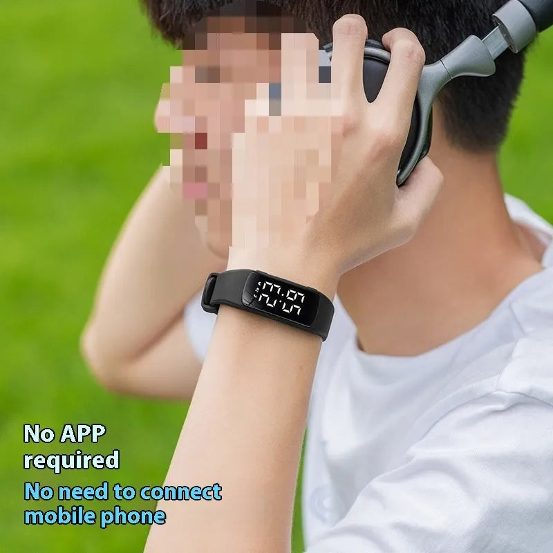 Vibration alarm clock watch with LED display and coloured silicone strap on a wrist.
