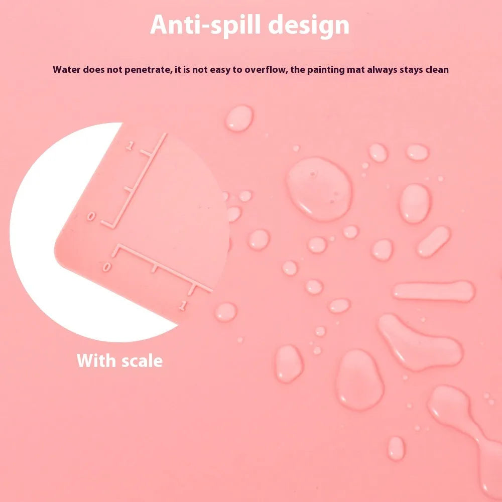 Light blue silicone painting mat with two bowl compartments on a wooden table.