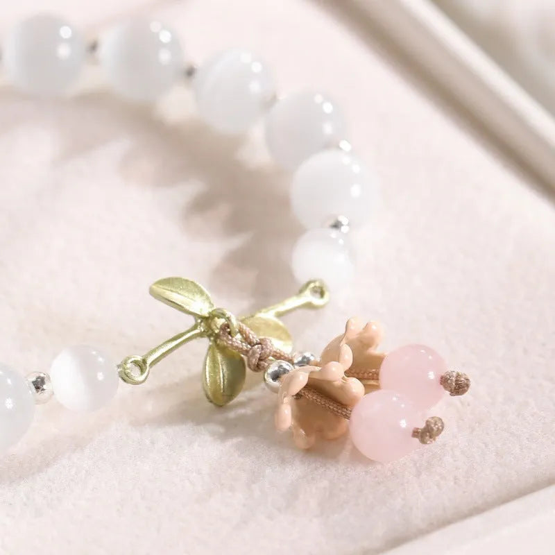 Close-up of a women's electroplated opal cat's eye stone beaded bracelet with diamond-shaped beads.