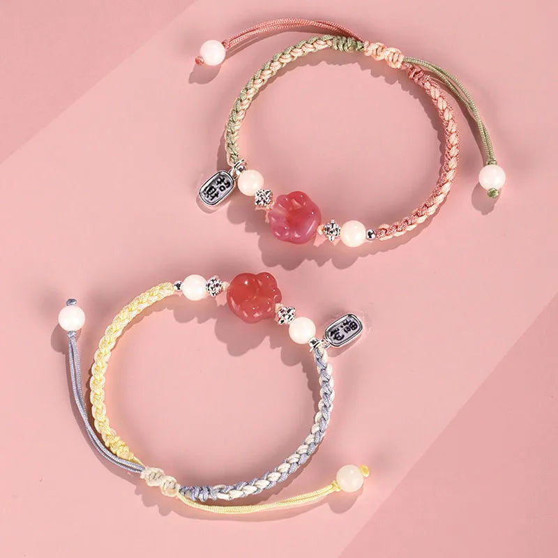 Handmade red cat's paw charm bracelet with pink woven band for couples.
