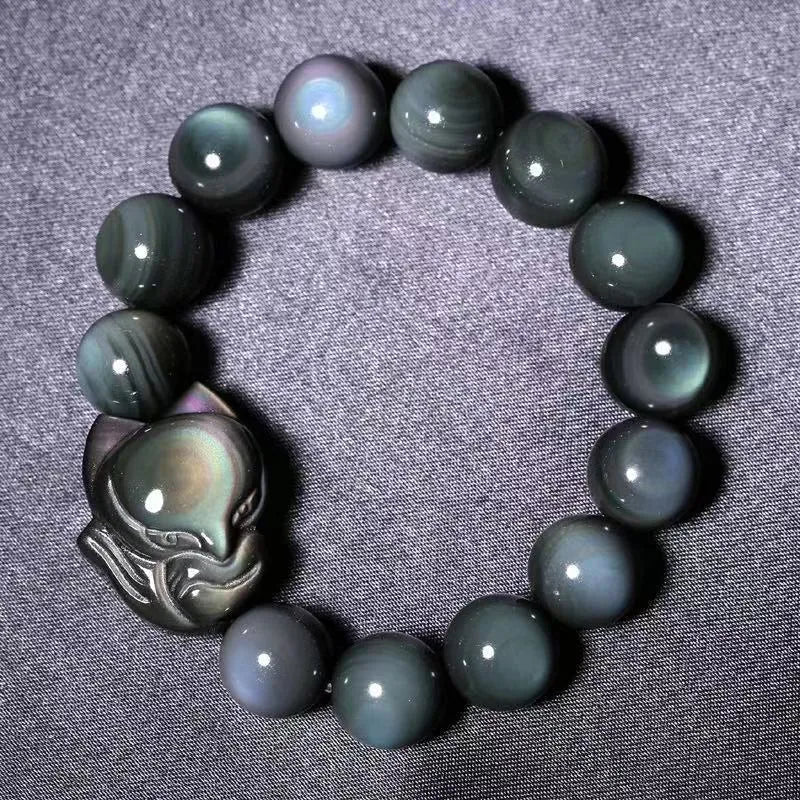 Obsidian stone bracelet with carved fox design on a central bead, shown in multiple size options.