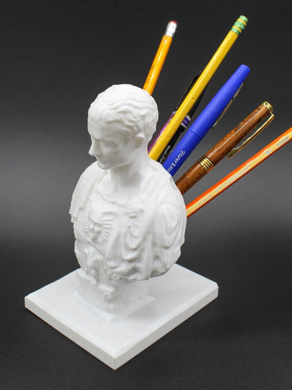 White synthetic resin American creative character model pen holder on a desk.