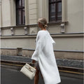 White loose-fit knitted cardigan jacket for women, shown with long sleeves.
