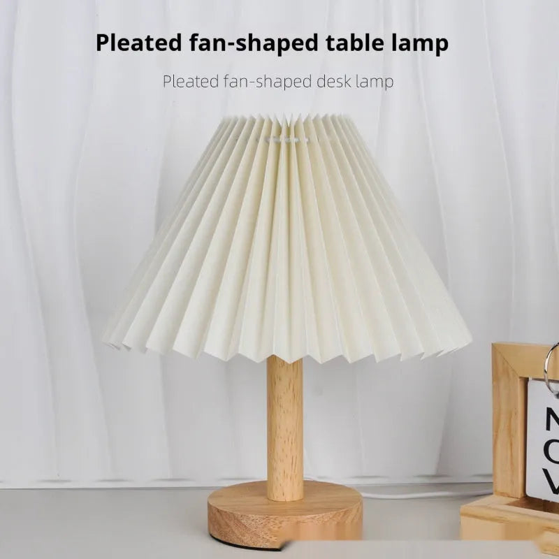 Vintage red pleated umbrella-shaped bedside lamp with remote control on a wooden nightstand.
