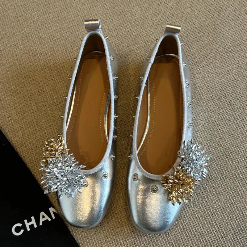 Women's silver Mary Jane flat shoes with a buckle strap and sheepskin upper.