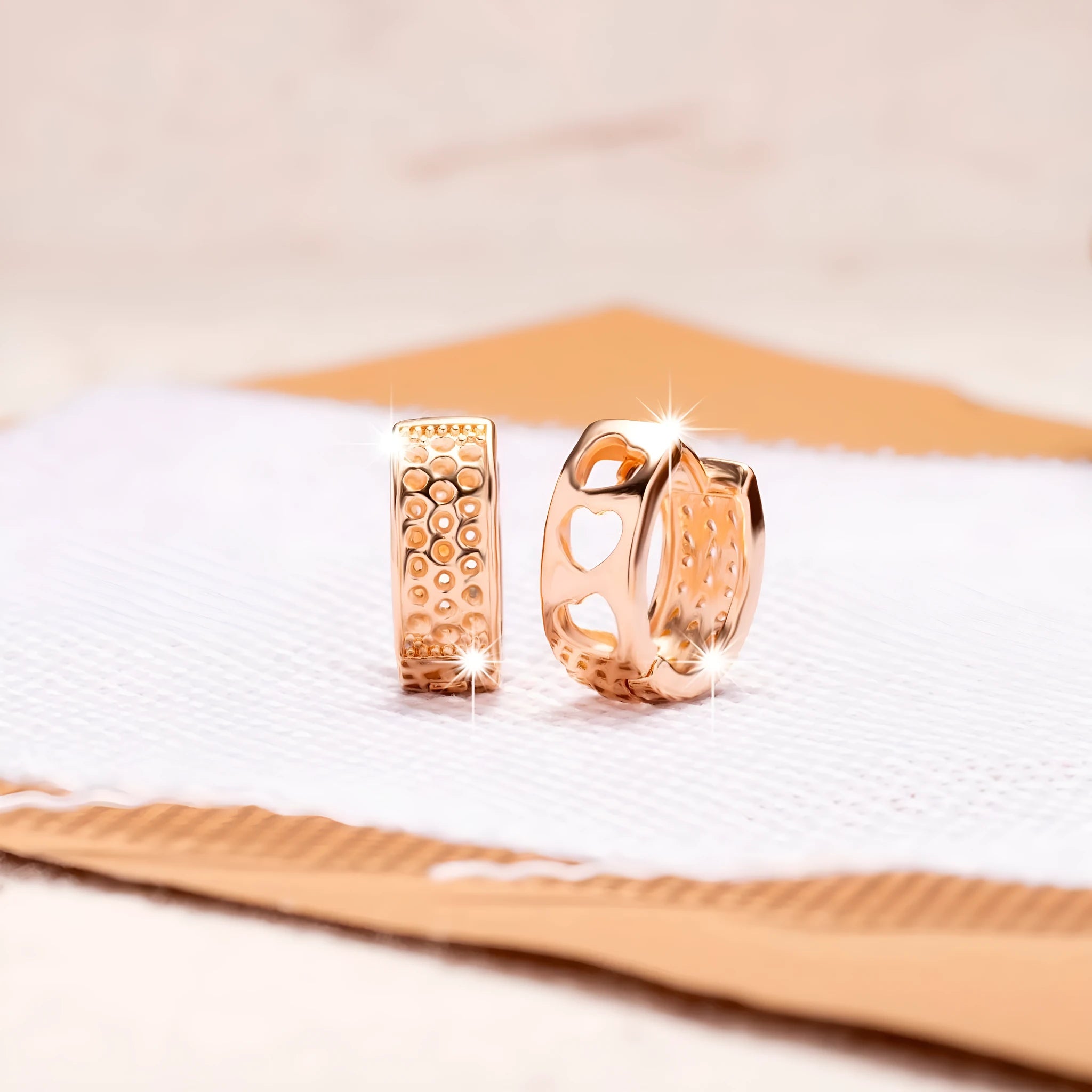 Rose gold tone women's earrings with a hollowed-out heart shape divided into three sections.
