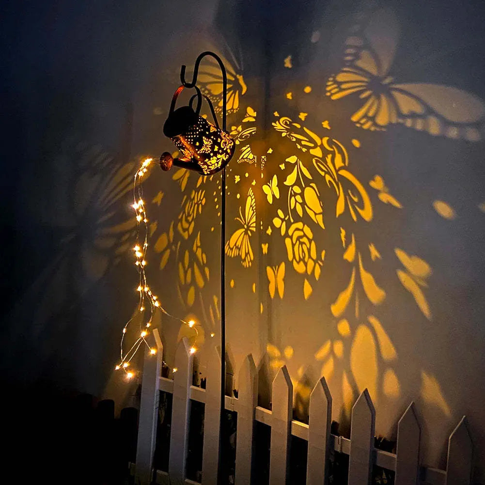Iron solar garden lamp with a tapered butterfly silhouette emitting warm white light.