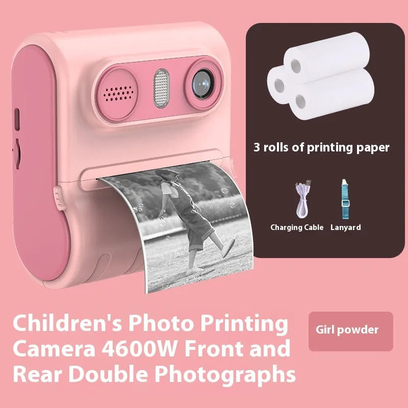Children's instant thermal printing camera in pink with dual lenses, including lanyard and charging cable on white background
