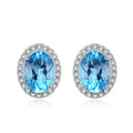 Four-piece sterling silver jewellery set with blue topaz gems showing geometric necklace, earrings, ring, and pendant