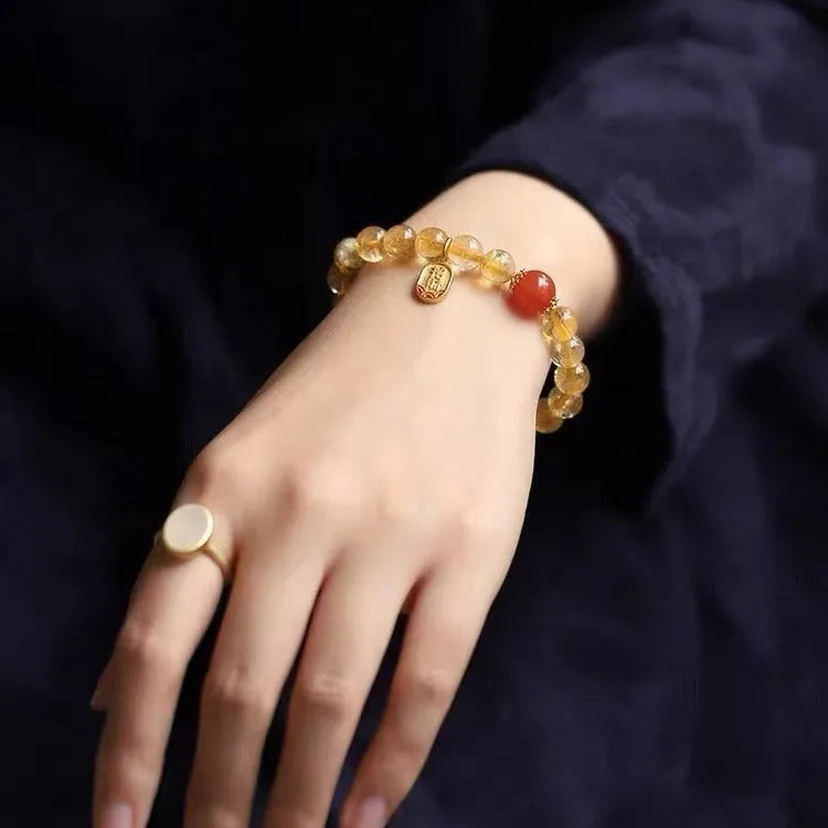 Polished natural red agate bead bracelet on a wrist, showing smooth beads.