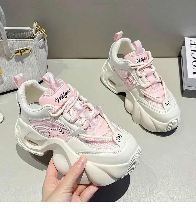 Women's pink sneakers with a thick sole, cross shoulder straps, and a mesh lining.